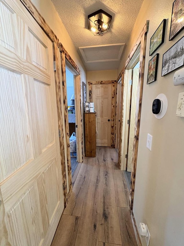 corridor featuring hardwood / wood-style flooring and a textured ceiling