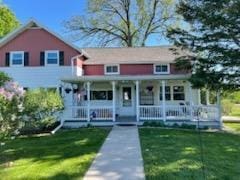 view of front of house with covered porch and a front lawn