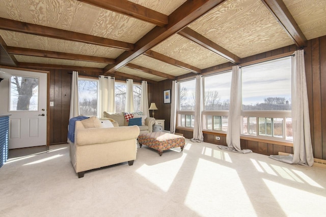 living room featuring carpet floors, vaulted ceiling with beams, and wooden walls