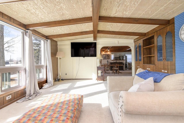 living room with arched walkways, light carpet, and lofted ceiling with beams