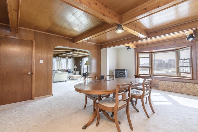 dining room with light carpet, plenty of natural light, and arched walkways