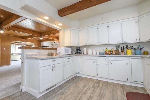 kitchen featuring light wood-style floors, beam ceiling, white cabinetry, and white microwave