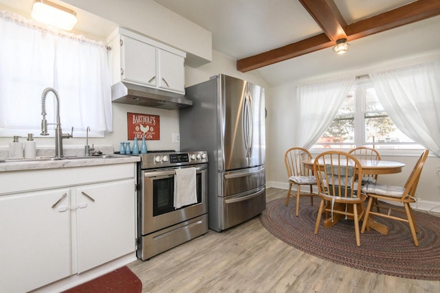 kitchen featuring white cabinets, stainless steel appliances, light countertops, under cabinet range hood, and a sink