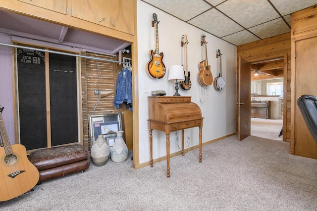 interior space featuring light carpet, a paneled ceiling, and baseboards