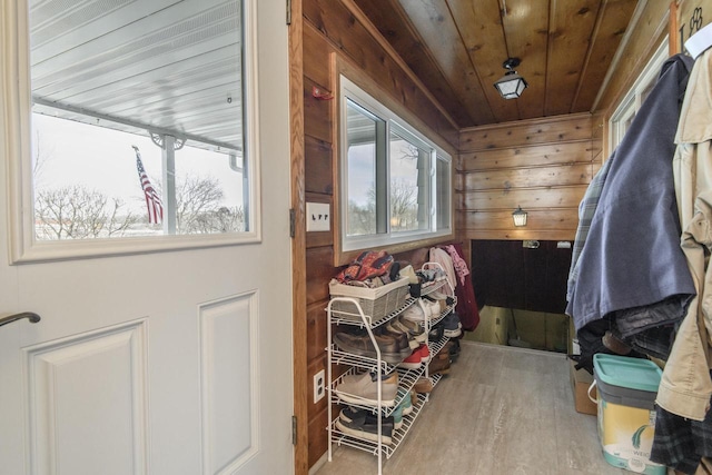 doorway to outside with wood walls, wooden ceiling, and wood finished floors