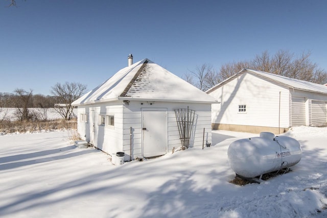 snow covered property featuring an outbuilding