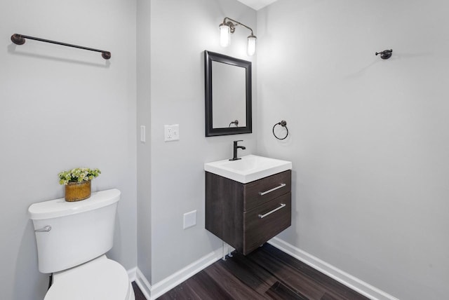 bathroom with vanity, wood-type flooring, and toilet