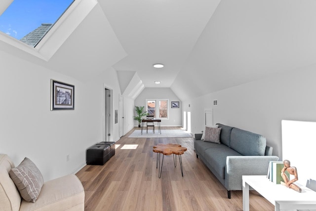 living room featuring lofted ceiling with skylight and light hardwood / wood-style flooring