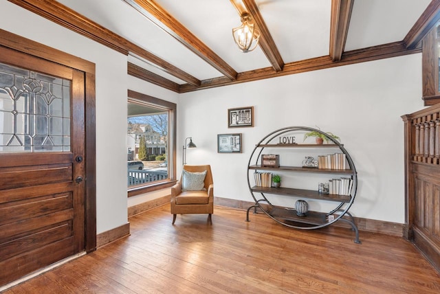 living area with beamed ceiling and light hardwood / wood-style floors