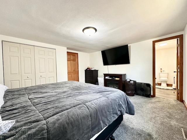 bedroom with carpet floors, a textured ceiling, and a closet