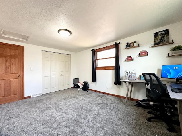 carpeted office space featuring a textured ceiling