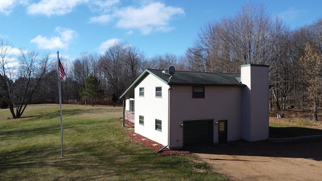 view of side of property featuring a garage and a lawn