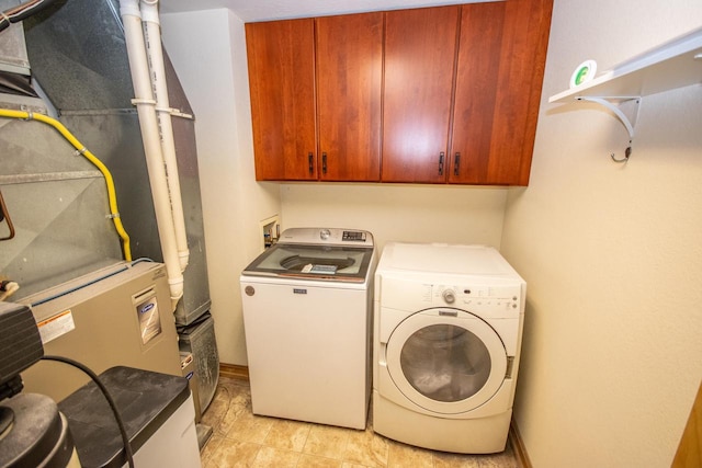 laundry area with washer and clothes dryer and cabinets