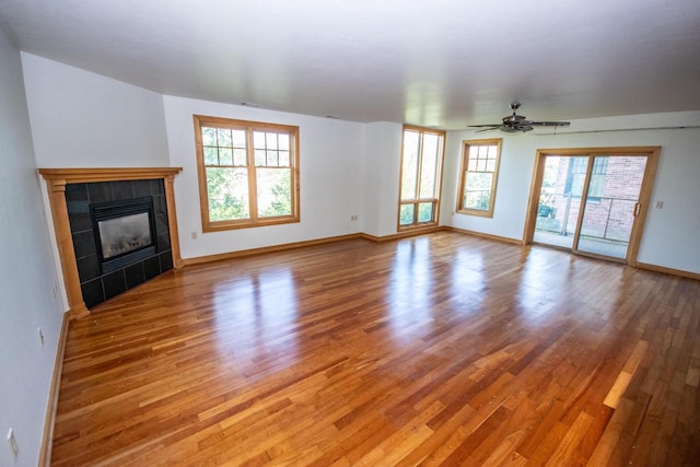 unfurnished living room featuring light hardwood / wood-style floors, ceiling fan, and a fireplace