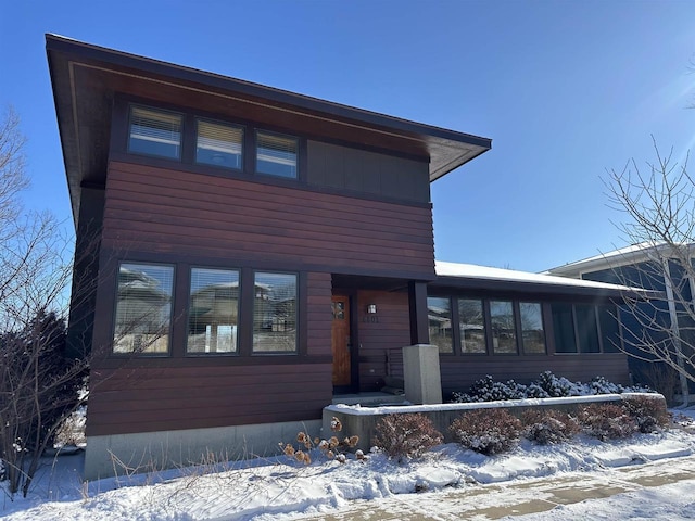 view of front of house with board and batten siding and a sunroom