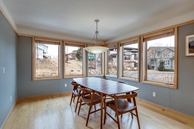 dining area featuring light wood-type flooring and baseboards