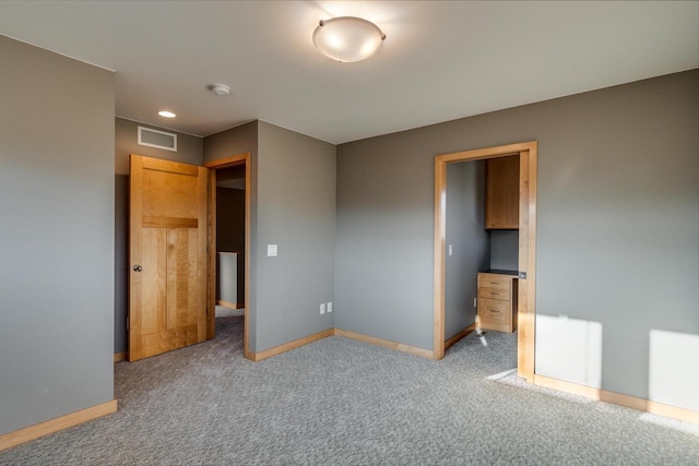 unfurnished bedroom with carpet flooring, visible vents, and baseboards