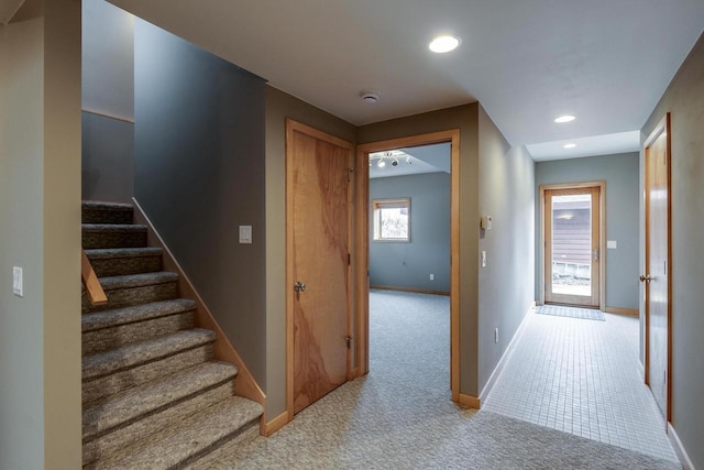 hall featuring light carpet, stairway, baseboards, and recessed lighting