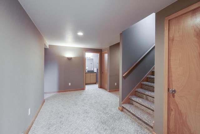 basement featuring carpet floors, stairway, and baseboards