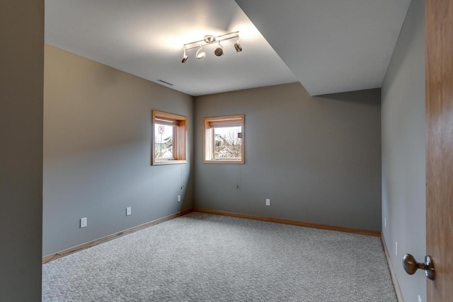 empty room featuring carpet and baseboards