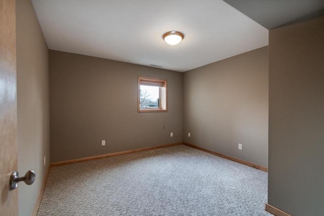 spare room featuring carpet flooring, visible vents, and baseboards