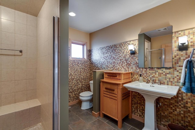 full bath featuring tile walls, visible vents, a shower stall, and toilet