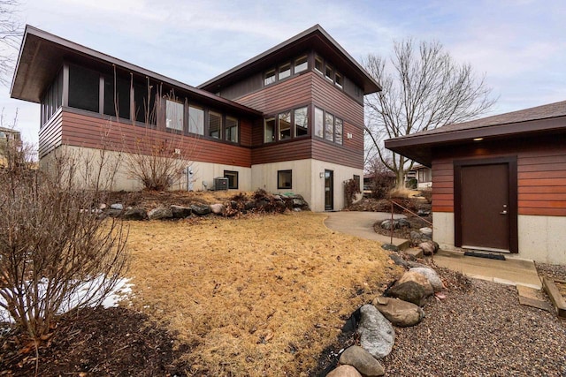 rear view of house featuring a sunroom and cooling unit