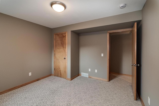 unfurnished bedroom featuring carpet floors, visible vents, and baseboards