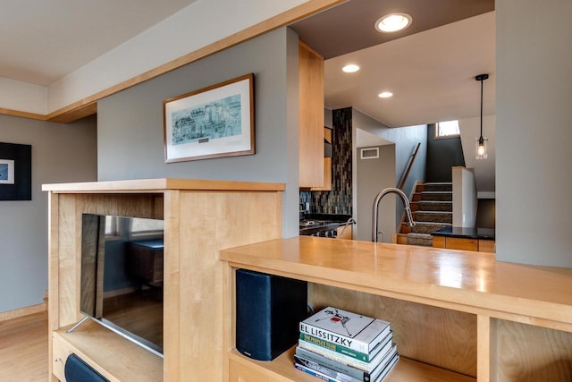 kitchen featuring recessed lighting, wood finished floors, visible vents, hanging light fixtures, and tasteful backsplash