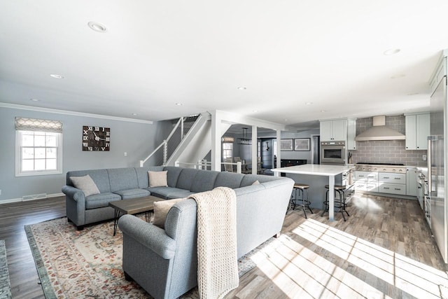 living room with light hardwood / wood-style flooring and ornamental molding