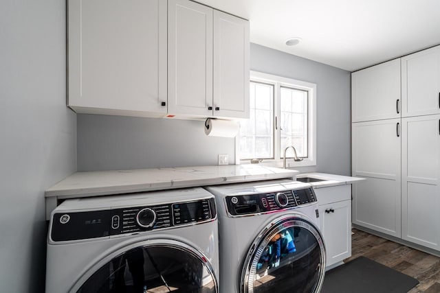 laundry room featuring washer and dryer, cabinets, dark wood-type flooring, and sink