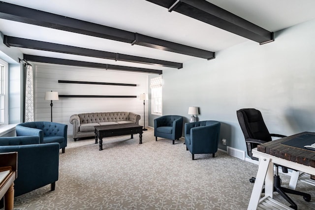 carpeted office space featuring beam ceiling