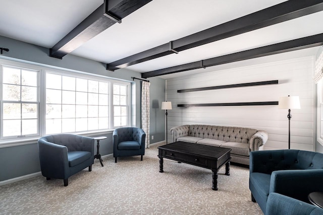 carpeted living room featuring beam ceiling, a wealth of natural light, and wooden walls