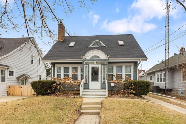 view of front of home featuring cooling unit and a front lawn