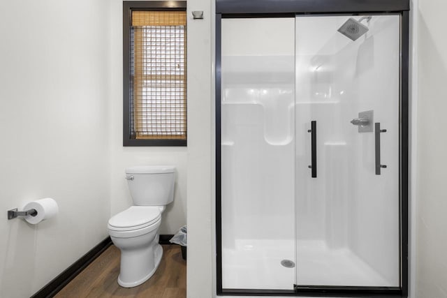 bathroom featuring wood-type flooring, toilet, and walk in shower