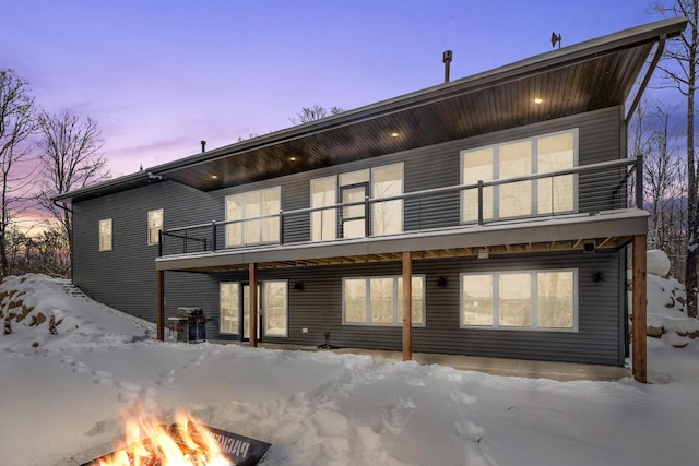 snow covered property with an outdoor fire pit