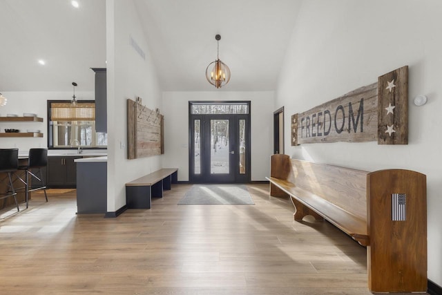 entryway with a healthy amount of sunlight, sink, a chandelier, and light wood-type flooring