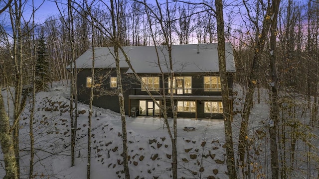 view of snow covered back of property