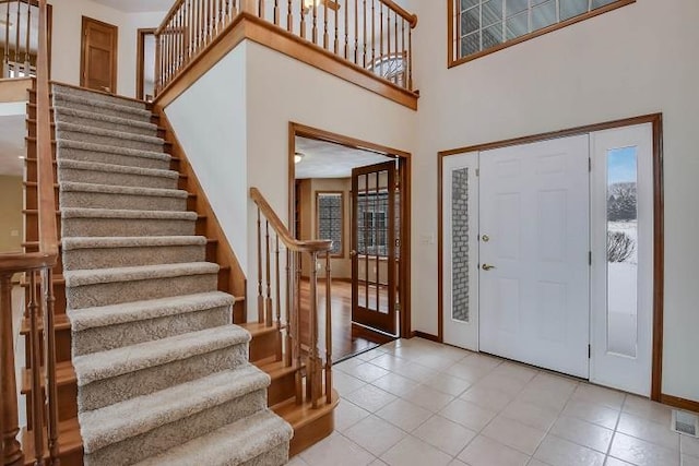 foyer with a high ceiling and light tile patterned flooring