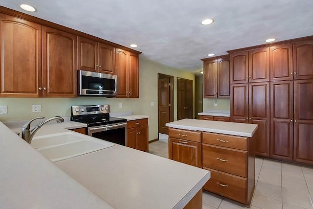 kitchen featuring appliances with stainless steel finishes, sink, a kitchen island, and light tile patterned floors