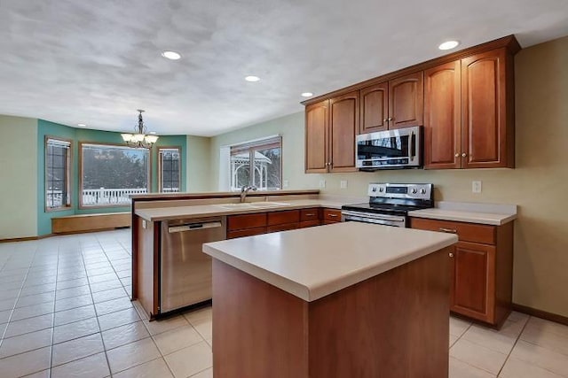 kitchen with light tile patterned flooring, sink, hanging light fixtures, a center island, and stainless steel appliances