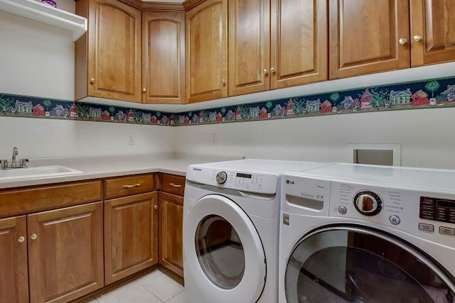 laundry room featuring cabinets, washing machine and dryer, sink, and light tile patterned flooring