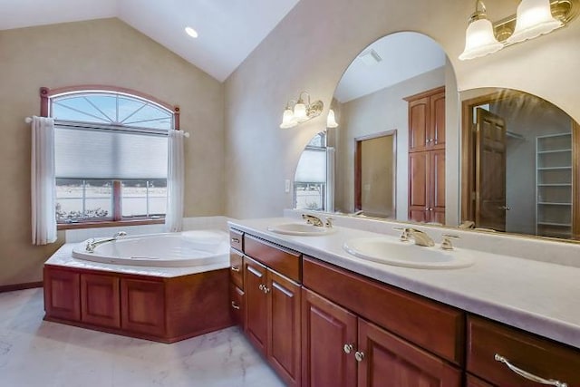 bathroom with lofted ceiling, vanity, and a washtub