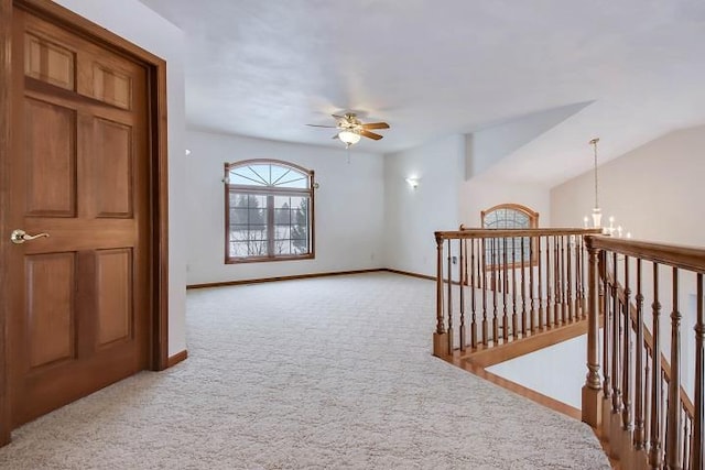 interior space featuring light carpet, lofted ceiling, and a chandelier