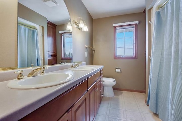 bathroom featuring vanity, plenty of natural light, and toilet