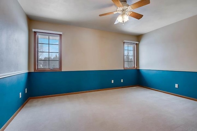 carpeted empty room featuring plenty of natural light and ceiling fan