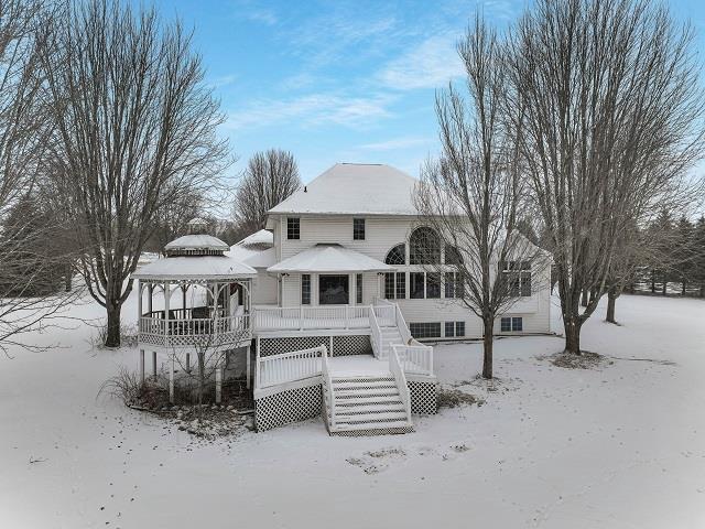 snow covered rear of property with a gazebo and a deck