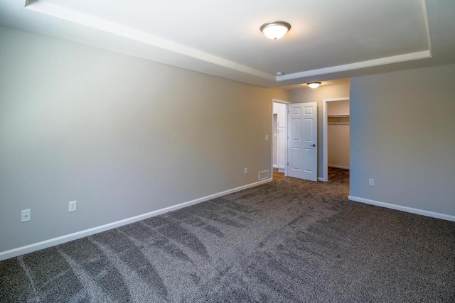 carpeted empty room with a tray ceiling