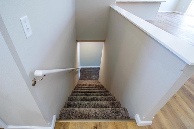 stairs featuring hardwood / wood-style floors