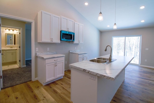 kitchen featuring white cabinetry, an island with sink, and sink